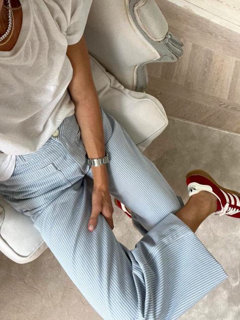 Port avec une paire de baskets bordeaux, le pantalon ray bleu et blanc se fait plus automnal qu'estival