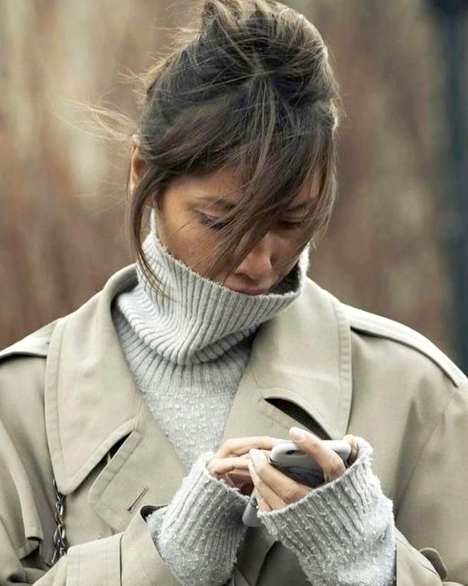 Mêlant pull trop grand, trench confortable et coiffure désinvolte, ce look a tout bon !