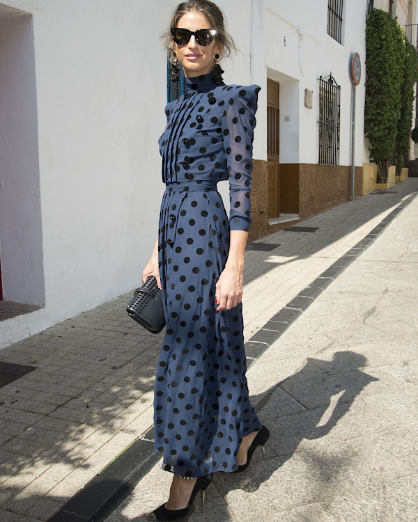 Robe longue bleu marine à pois noirs portée avec escarpins noirs, lunettes de soleil et sac seau noir